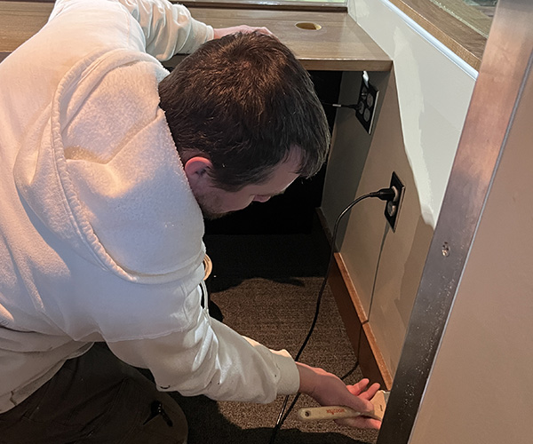 Cornerstone crew member doing interior detail work along a baseboard
